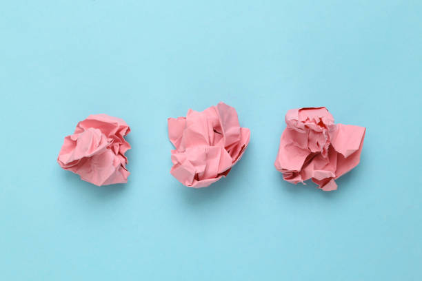 istock Pink crumpled sheets of paper on a light blue background. Minimal concept 1411078707