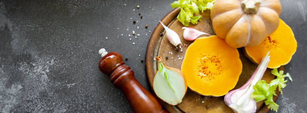 istock Banner vegetables on cutting board: orange squash, celery, garlic and spices - pepper. salt. Black background. Copy space 1411080046