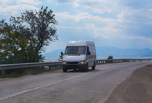 Van moves along the road along the sea coast