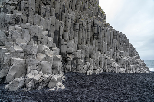 Backgrounds of Gardar Basalt Columns on Reynisfjara Black Sand Beach - natural pyramid made of hexagonal-shaped basalt columns that looks like a staircase to the sky. This basalt cliff is called Gardar. Iceland.