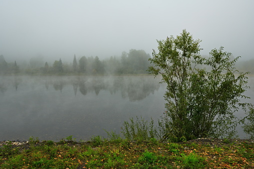 Russia. South of Western Siberia, Kuznetsk Alatau. Foggy autumn morning on the rocky bank of the Tom River near the village of Chulzhan.