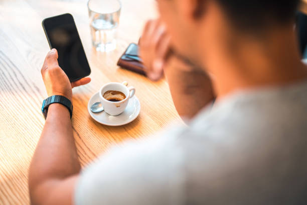 istock Asian Male Using A Smart Phone And Drinking Coffee 1411082945