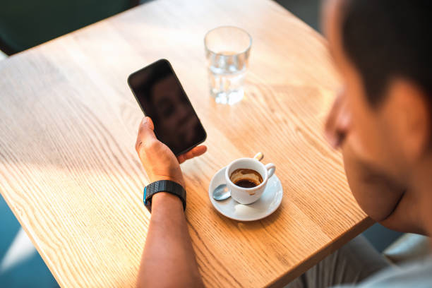 istock Asian Male Using A Smart Phone And Drinking Coffee 1411082970