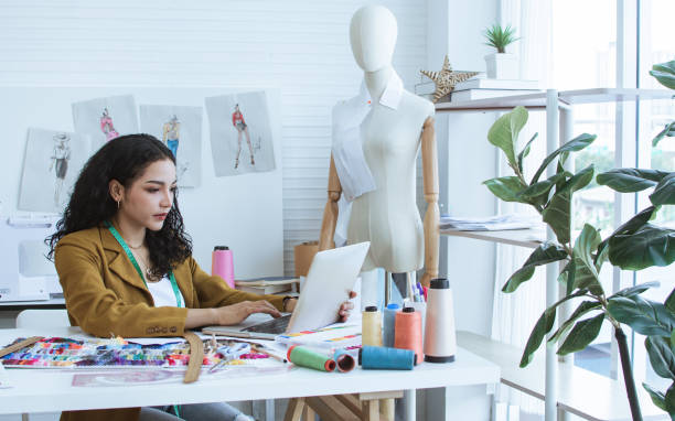 istock Professional female tailor wearing modern suit, working, using computer for online purchase in shop, home studio, making, designing fashion dress, clothes. Small Business, Lifestyle Concept. 1411085678