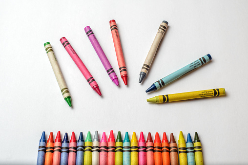 Group multicolored crayons messy and isolated on white background. Crayons of different colors in disorder.