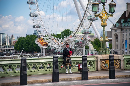 London, United Kingdom - June 07, 2022:  Pipe player on Westminster Bridge