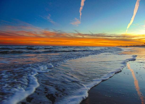 istock Low view of water rushing on the beach in front of sunset 1411090117