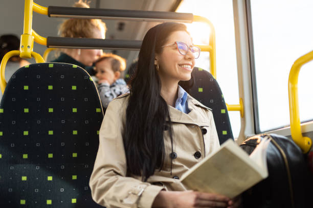 istock Woman holding a book while traveling by bus 1411092214