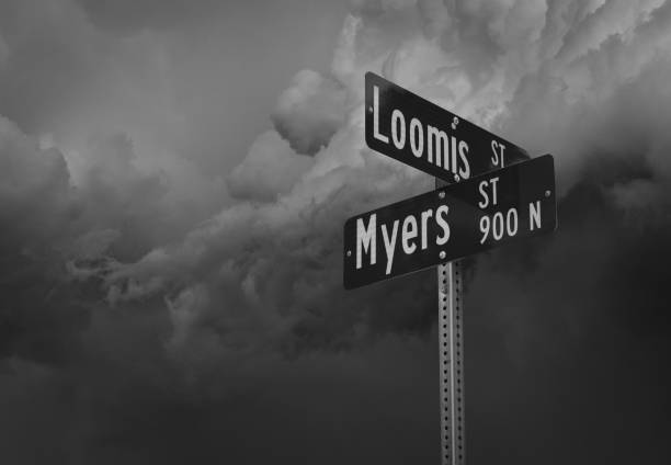 Myers and Loomis street signs in black and white, with ominous clouds in background creating a scary effect