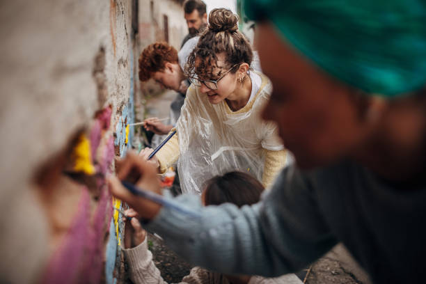 Street artists painting on wall