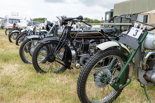 West Bay.Dorset.United Kingdom.June 12th 2022.A row of restored vintage motorcycles are on display at the West Bay vintage rally