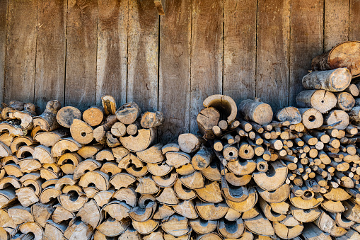 firewood stacked near the entrance of the barn