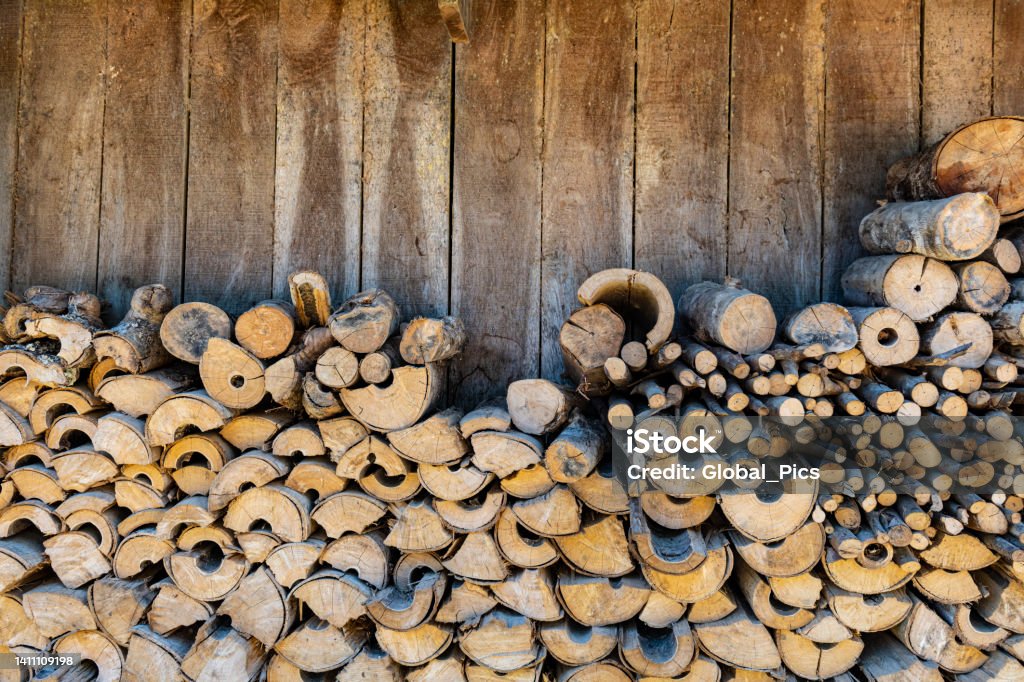 Stack of firewood Image of a stack of firewood by a wooden wall Firewood Stock Photo
