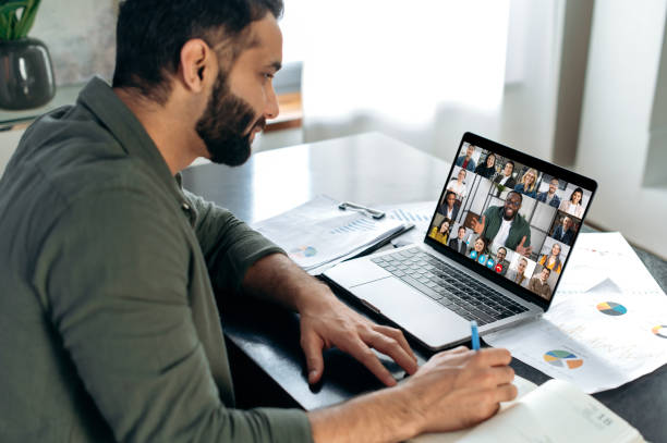 istock Successful indian man using a laptop, conducts virtual meeting with business partners on a video call. Group of diverse multiracial business people on laptop screen talking by video conference 1411110334