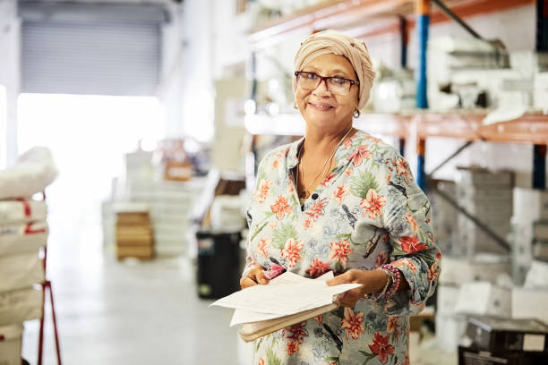 istock Smiling mature manager doing inventory in a warehouse 1411110548