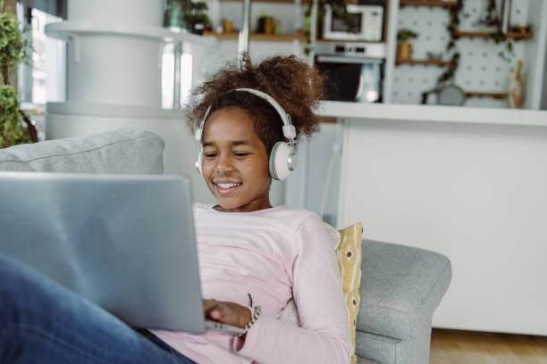 istock Little girl using laptop at home 1411110571