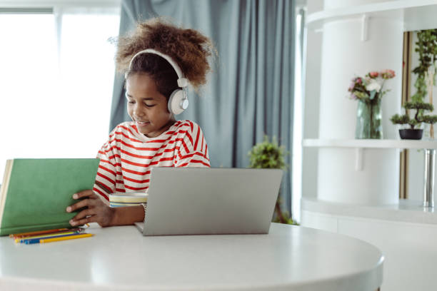 istock A little African-American girl is learning at home and using laptop 1411111179