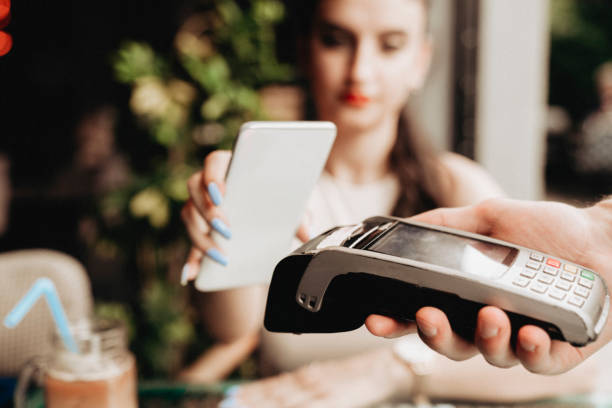 istock young woman paying with smartphone in a cafe 1411111285