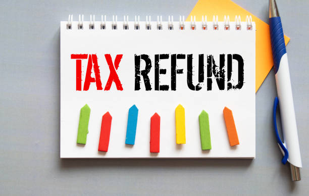 istock Notebook with a Business notes TAX REFUND on the office table with tools. 1411111625