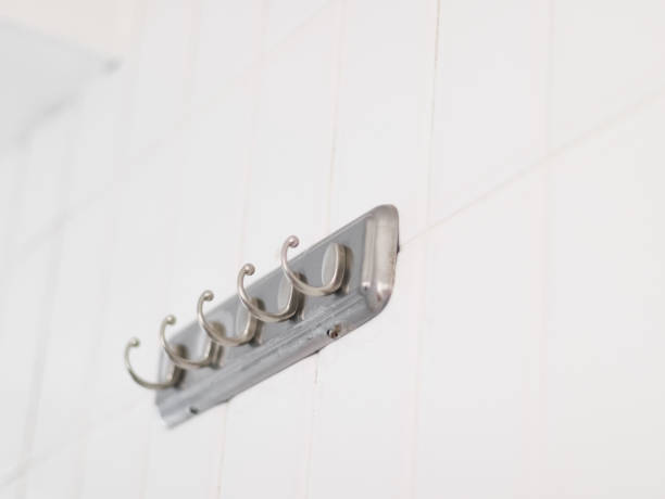istock Old and dirty with a little rust and mold metal hanger on a tiled white wall 1411114931