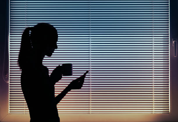 istock Young woman in office setting drinking coffee and using smart phone. 1411116036