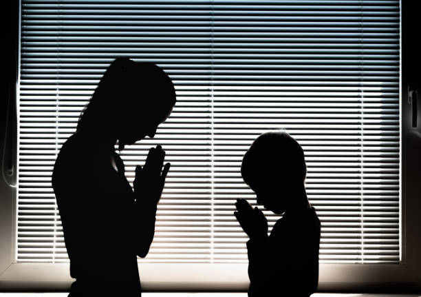 istock Mother and child praying together indoors 1411116094