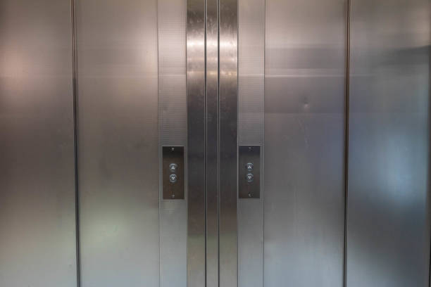 istock Symmetrical metal elevator doors with buttons to go up or down 1411116149