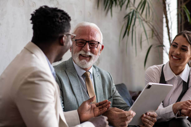 Mixed age group of colleagues having a laugh at work stock photo