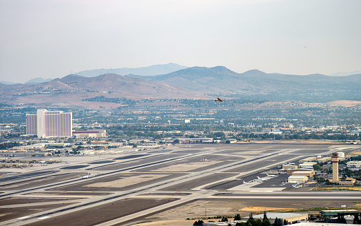 High angle view of the Reno Tahoe Airport and surrounding area with a small plane taking off and a Jet on the runway.