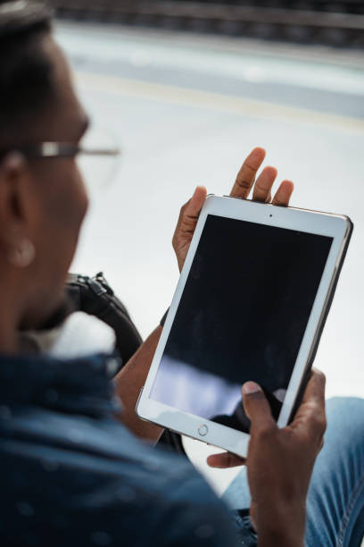 istock Perspective shot of african man using a tablet computer at a train station 1411118303