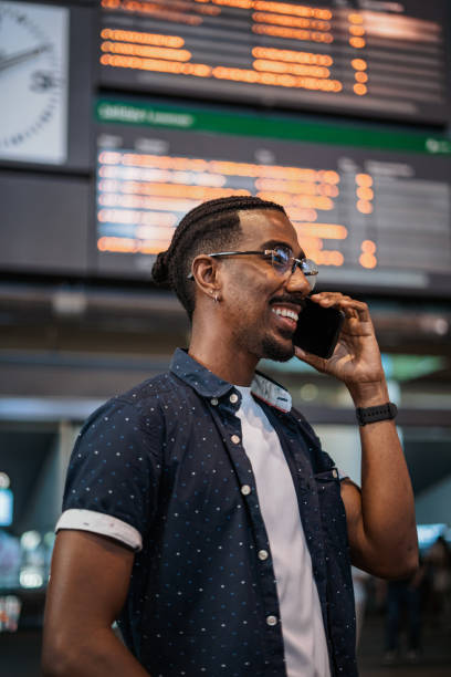 istock African man making a call with a friend while he is waiting at a train station 1411118324