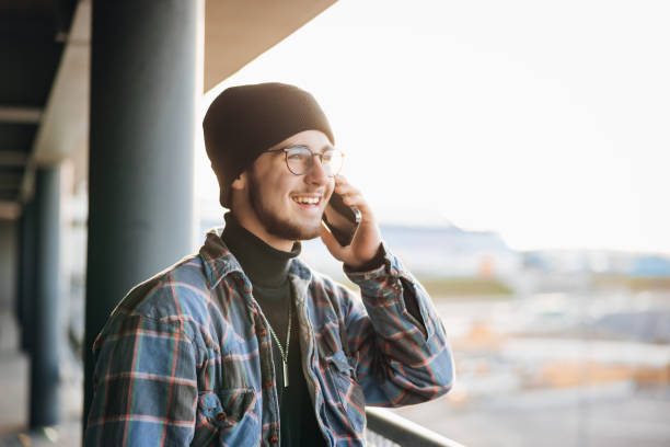 Smiling Young Man Having a Phone Call With His Mobile Phone stock photo
