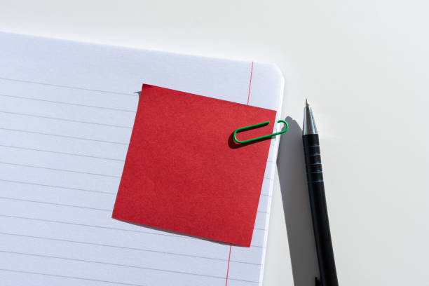 istock Sticky Note With Important Message Clipped On Opened Notebook On Desk With Pen. Crutial Information Presented On Memo Attached On Notepad Next To Pencil. 1411124523
