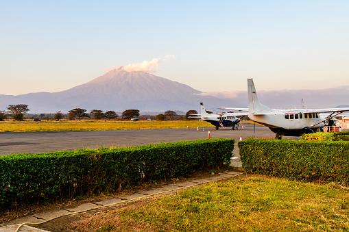 Small propeller airplanes at airport at sunset, mount Meru at background. Arusha, Tanzania