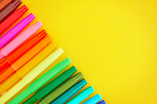 Back To School Background with Rainbow Of Felt Tip Pens on Bright Yellow Background. Space for text