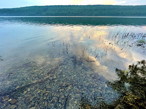 Clouds are reflected at dusk on the surface of Hemlock Lake in the Finger Lakes region of New York.