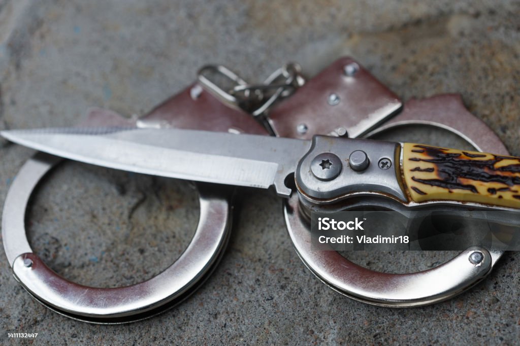 the knife is handcuffed. crime concept the knife is handcuffed. crime concept. High quality photo Customs Stock Photo