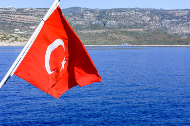 istock Red turkish flag waving over the Mediterranean sea 1411135239