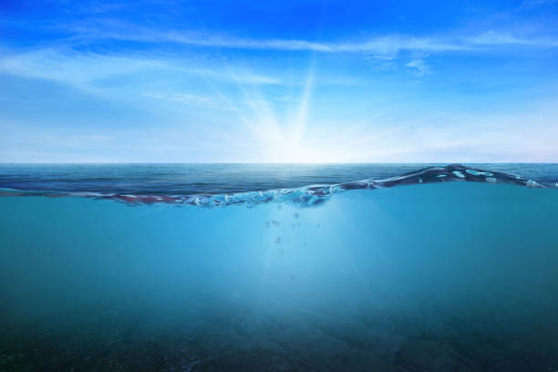 istock BLUE UNDER WATER waves and bubbles. Beautiful white clouds on blue sky over calm sea with sunlight reflection, Tranquil sea harmony of calm water surface. Sunny sky and calm blue ocean. 1411135730