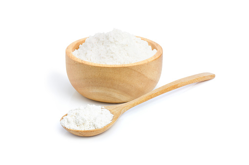 Closeup tapioca starch (potato flour or powder) in wooden bowl and spoon isolated on white background.