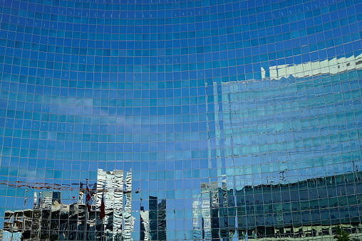 Singapore, Singapore - May 26, 2015: Reflection of skyscrapers in Central Business District of Singapore during daytime, showing busy vehicle traffic.