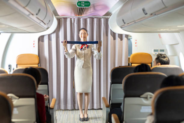 istock Asian flight attendant is demonstrating safety procedure using seat belt before taking off in the airplane for cabin crew and airline business concept 1411146932
