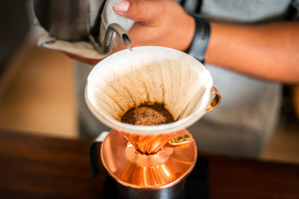 istock Drip coffee, barista pouring water on coffee ground with filter 1411147293