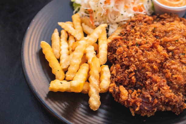 istock Pork batter with potato sticks and mayonnaise on a black plate 1411150111