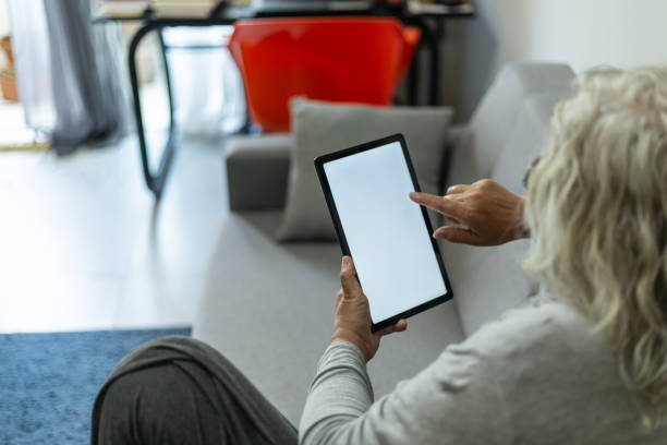 istock Woman in glasses using tablet at home 1411151278