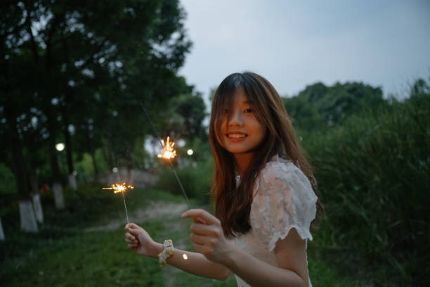 istock A girl who plays fireworks at night 1411154450