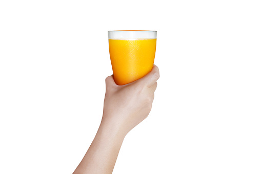 female hand holding a glass of orange juice with white background The concept of freshly squeezed orange juice contains vitamin C for health benefits.