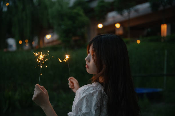 istock A girl who plays fireworks at night 1411155554