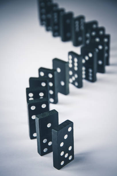 istock Black dominoes chain on white table background 1411156362