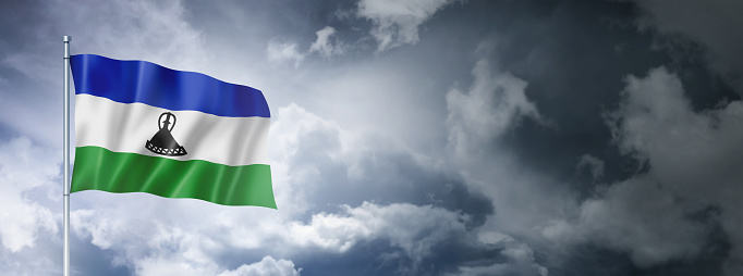 Lesotho flag on a cloudy sky, three dimensional render